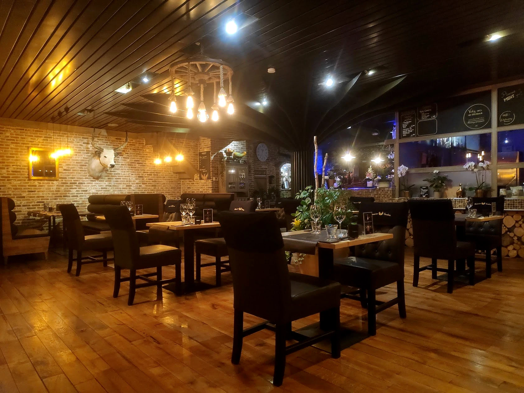 Phoenix Garden na de restyling met dezelfde achterwand, warme verlichting, hout en grillrestaurant-sfeer.