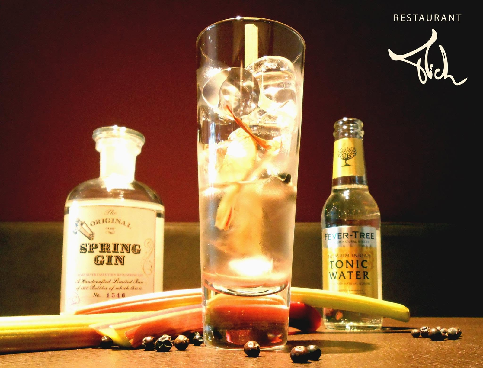 Gin-tonicpresentatie met fles, glas, tonic en garnituren naast het Restaurant Mich-logo.